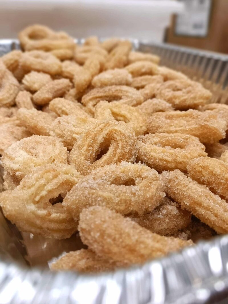 A tray of original churros, crispy cinnamon sugar mini churro loops with chocolate and dulce de leche.