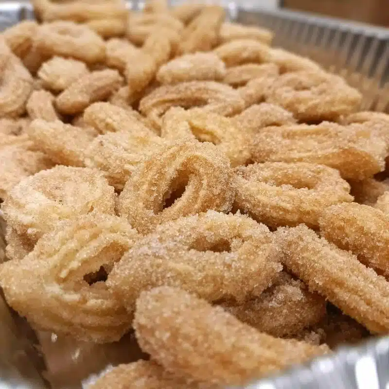 A tray of original churros, crispy cinnamon sugar mini churro loops with chocolate and dulce de leche.