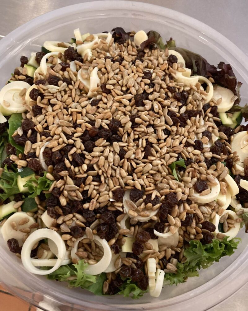 Bowl with dorada salad, featuring local greens, heart of palm, pickled green beans, toasted sunflower seeds. Served with mustard vinaigrette on the side.