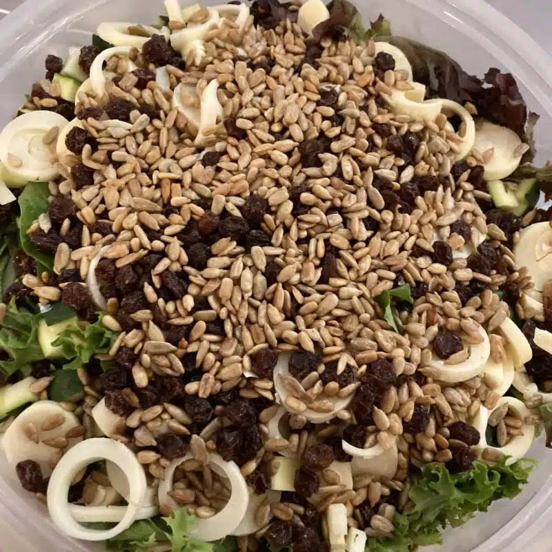 Bowl with dorada salad, featuring local greens, heart of palm, pickled green beans, toasted sunflower seeds. Served with mustard vinaigrette on the side.