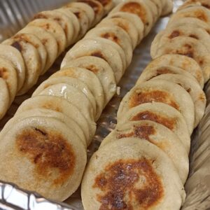 Mini Pupusas in the jalapeno black bean flavor, featuring corn dough pocket and serve with salsa, curtido and pickled red onions.