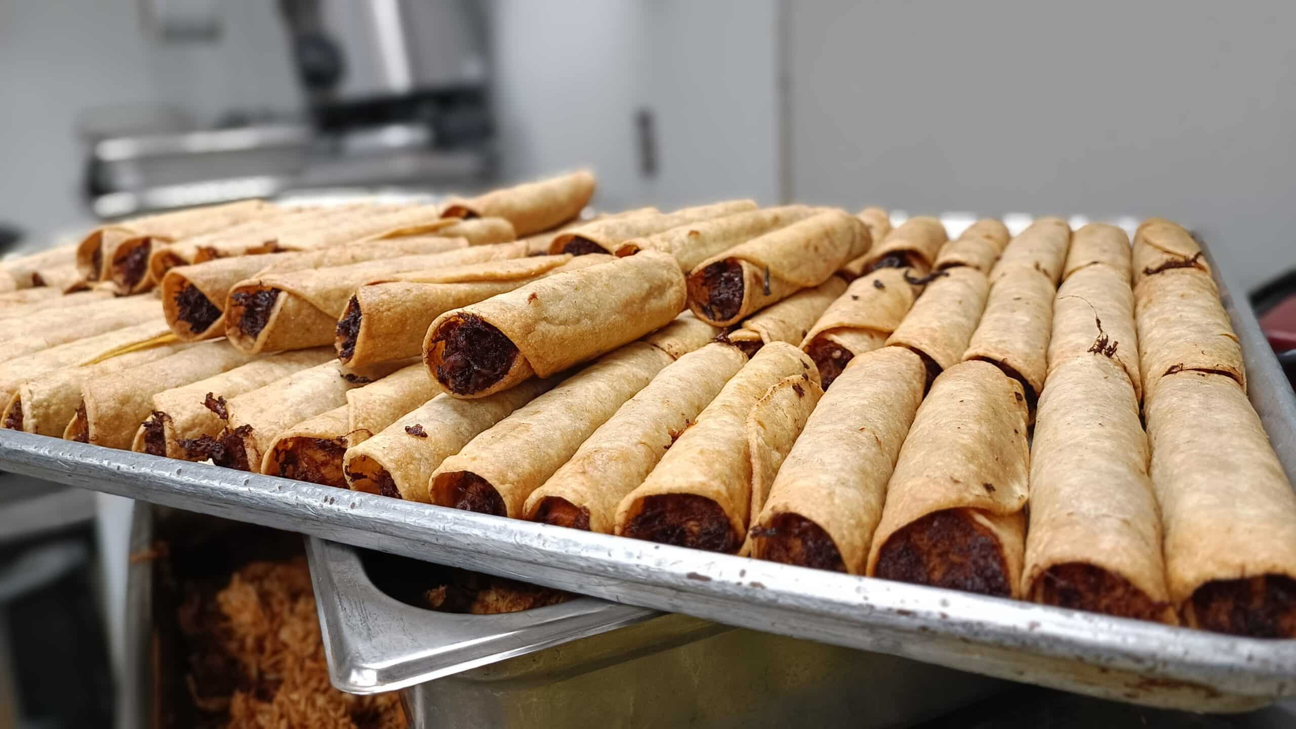 Guatemalan taquitos tray contains taquitos filled with veggies, meat or cheese.