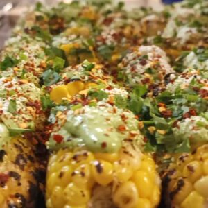 A mouthwatering tray of El Merkury's street corn, topped with delicious ingredients.