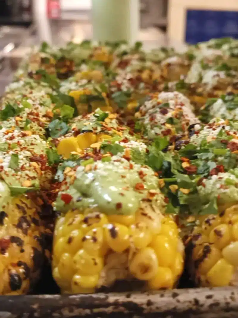 A mouthwatering tray of El Merkury's street corn, topped with delicious ingredients.